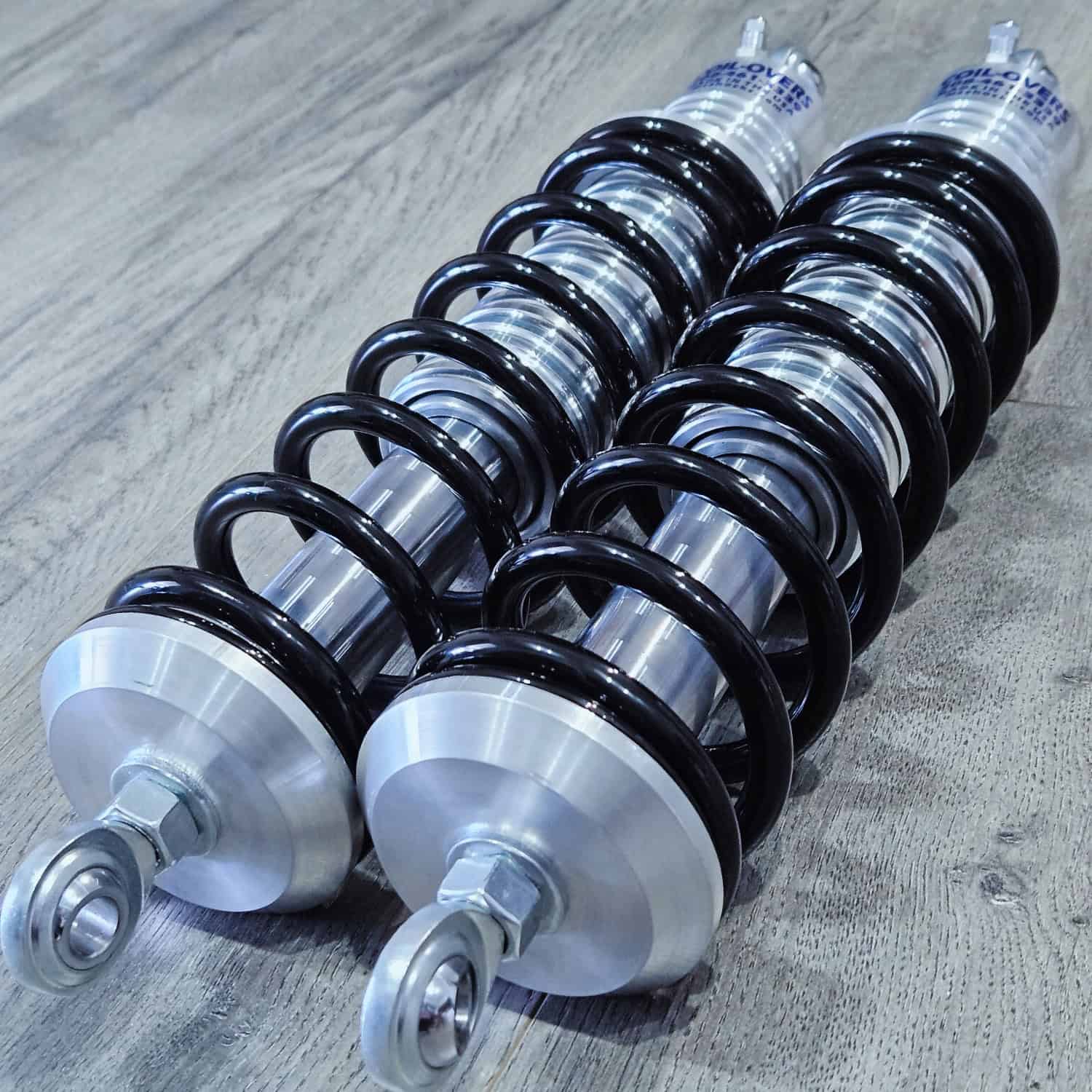 Close-up of automotive shock absorbers with coil springs, ideal for truck and car suspension upgrades.
